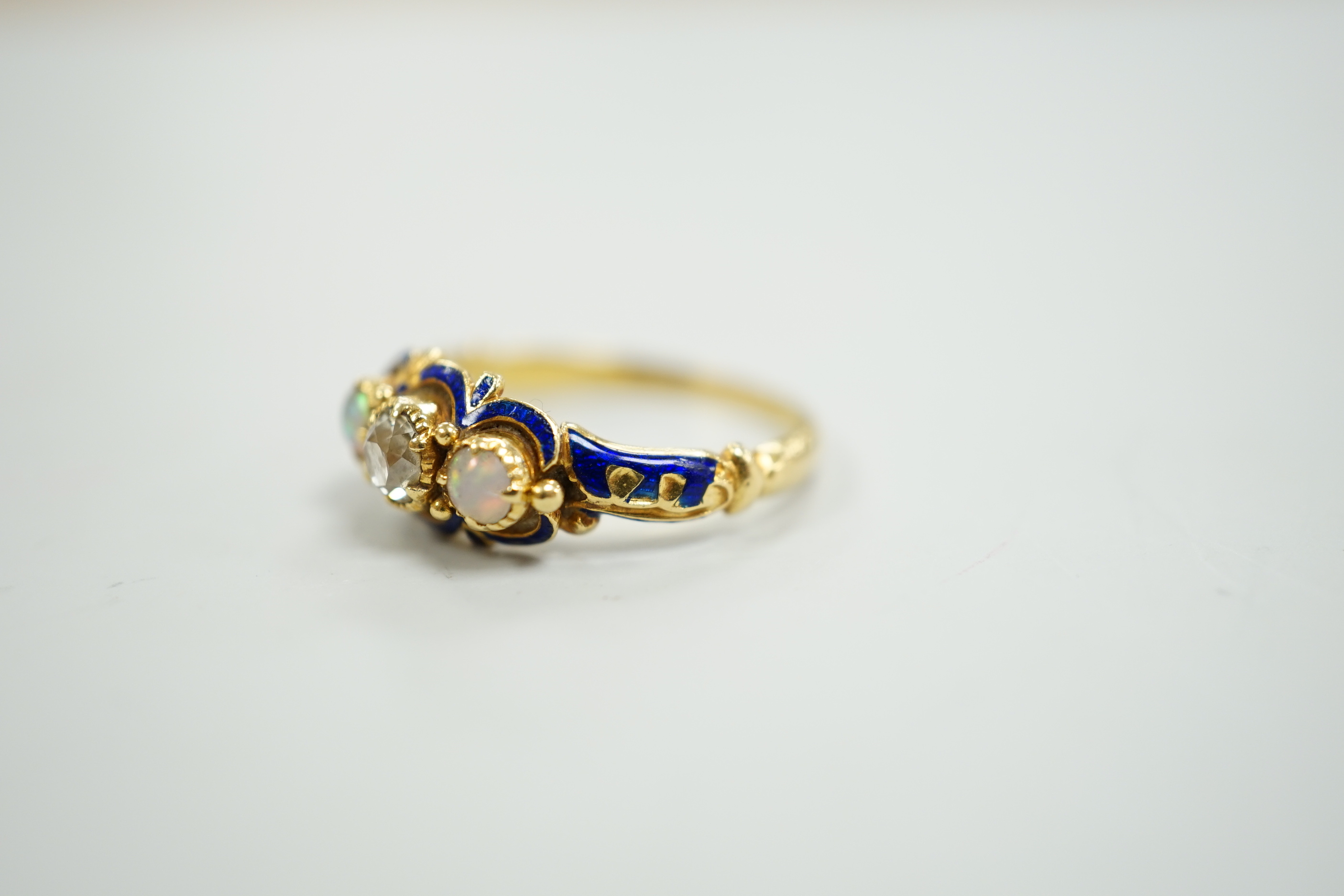 A late Victorian yellow metal, single stone diamond, two stone opal and enamelled dress ring, size K, gross weight 3 grams.